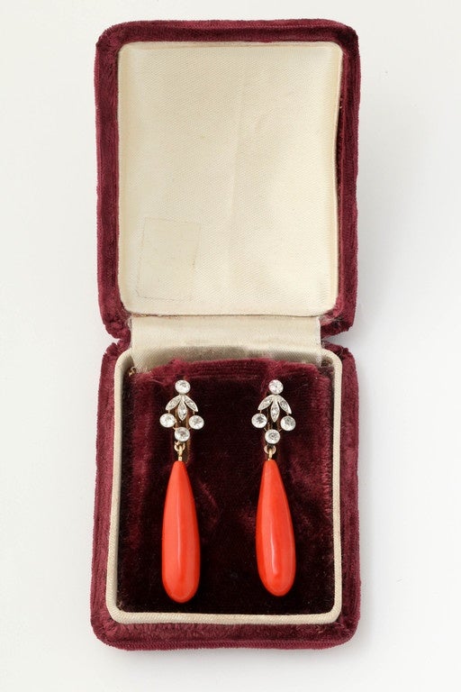 18kt gold Pendant-Drop Pierced Hanging Earrings Comprised Of 2 Oblong Tear-Drop Shaped High Quality Oxblood Color Coral dangles further elegantly embellished with numerous antique cut diamonds set in an unusual design pattern. Earrings are European