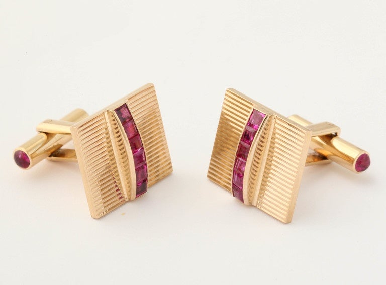 14 kt ridged gold gentlemen's Cufflinks Centering 12 super high quality French Cut Rubies and exhibiting an easy click on mechanism in back for easy wear and easy fastening for  the cuff of one's shirt Back of Cufflinks further embellished with  4
