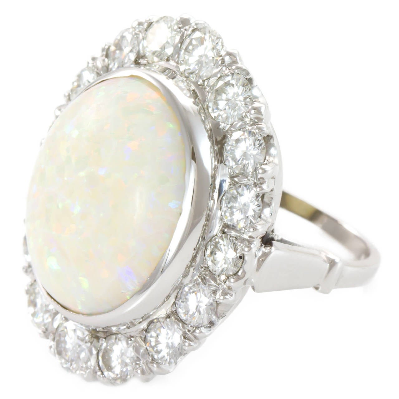 Ladys Cabochon White Opal approximately 13.05 carats. Approximately 4.00 carats of very clean and near colorless Round Brilliant Diamonds encircle the center Opal. Ring is cast in Platinum and good craftsmanship. Ring is easily sizable. 

One (1)
