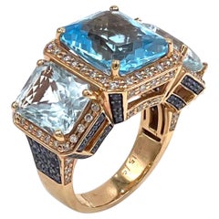 Bague à trois pierres en or rose 18 carats, topaze bleue taille radiant, saphirs et diamants