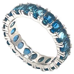 Anillo de eternidad de oro blanco de 14 quilates con topacio azul de Londres ovalado de 5,29 quilates