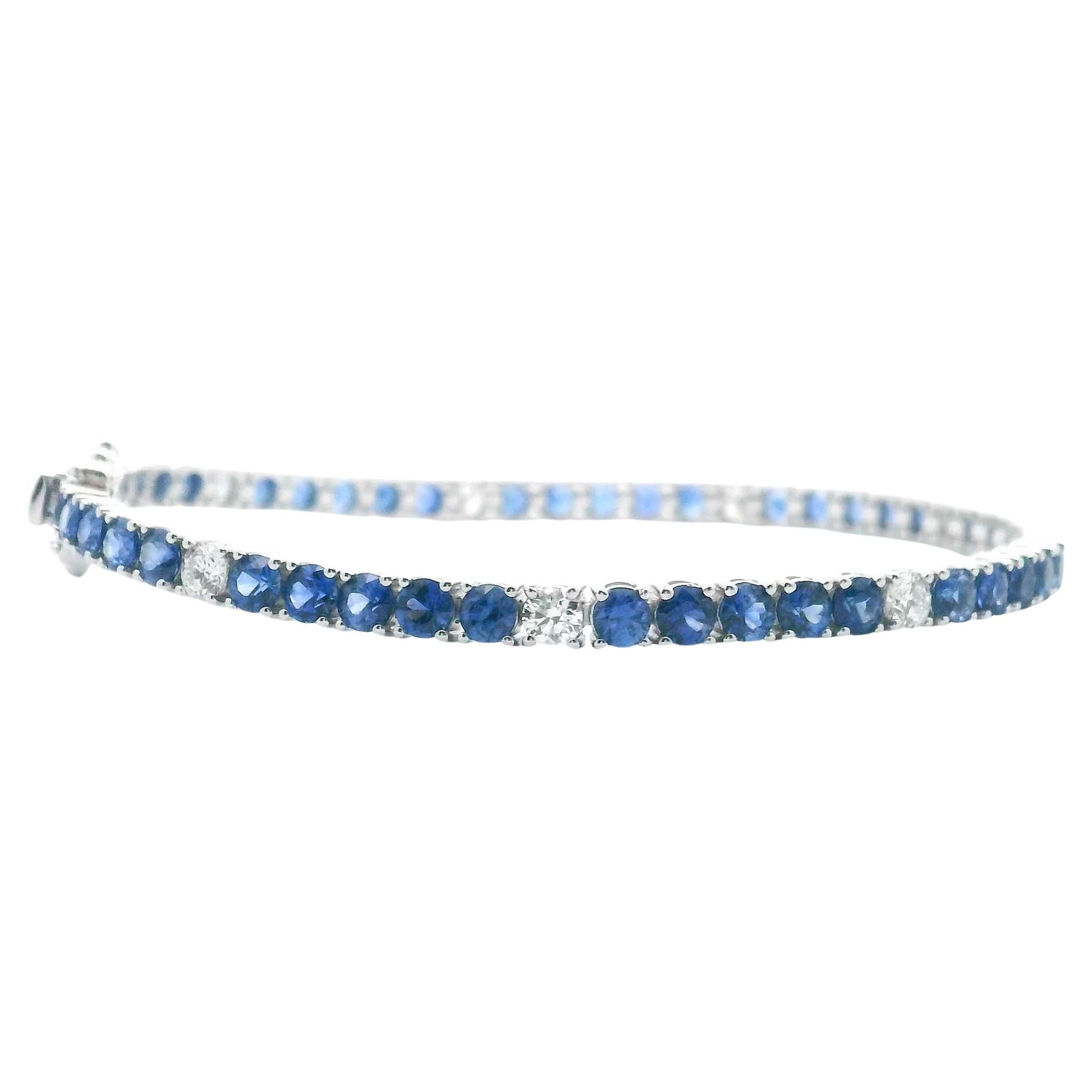 14K white gold line tennis bracelet with round faceted sapphires weighing 5.95 carats total and round brilliant-cut diamonds weighing 0.95 carats total. 

* 7 inches long.
* Has a double figure 8 safety clasp.
* Diamond are H color, SI