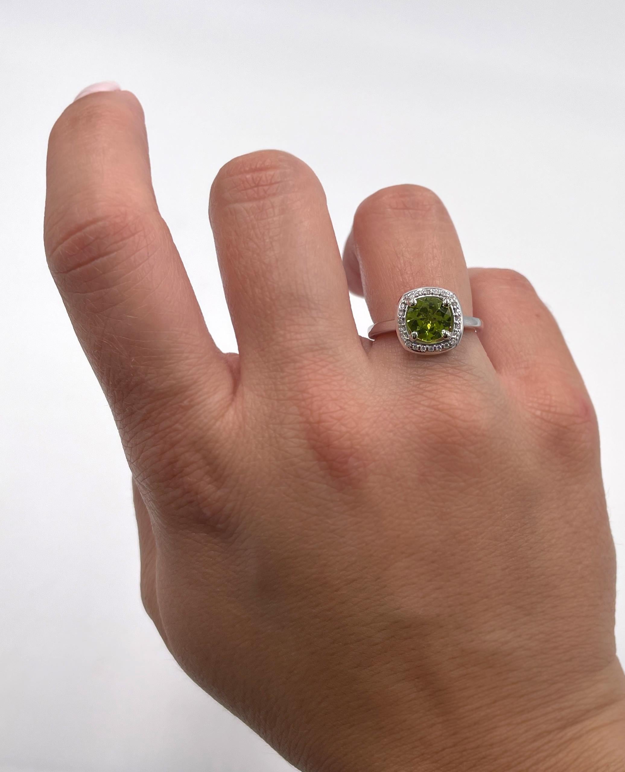 Anello in oro bianco 14K con un peridoto rotondo sfaccettato da 1,25 carati e diamanti da 0,10 carati.

La misura delle dita è 5,75, ma può essere aumentata o diminuita fino a 2 taglie.