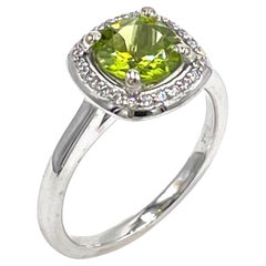 Anello con peridoto rotondo e diamante a raggiera in un'incastonatura minimalista in oro bianco 14K