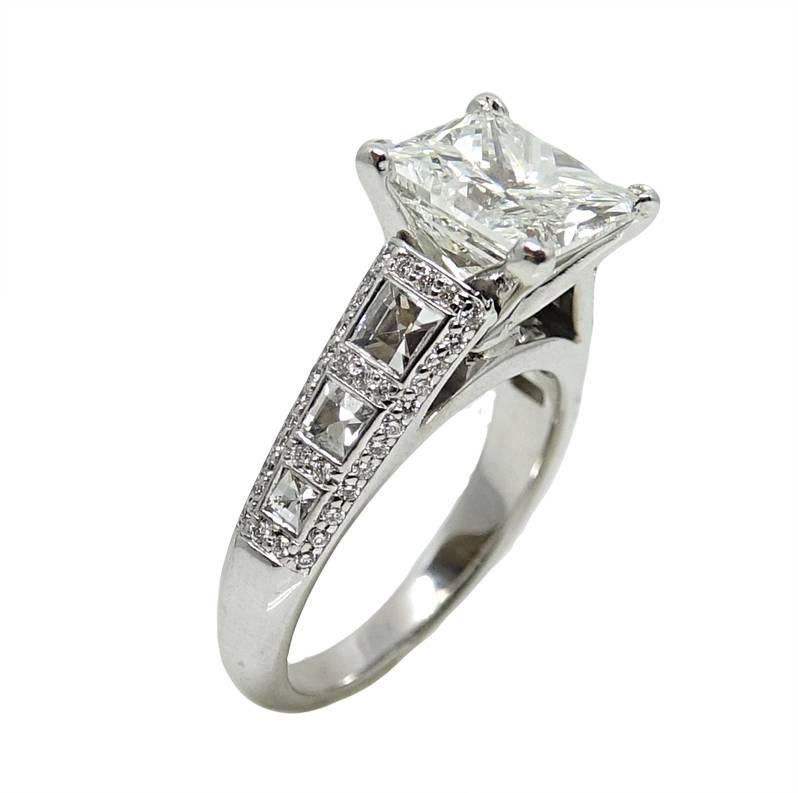 This 18K White Gold Engagement Ring Has A Center Princess Cut Diamond Weighing A Total Carat Weight Of 3.57, H in Color and SI1 In Clarity. 6 Blaze Widow Diamonds Sit Along The Shank Weighing A Total Carat Weight Of 0.87 Carats. This Beautiful