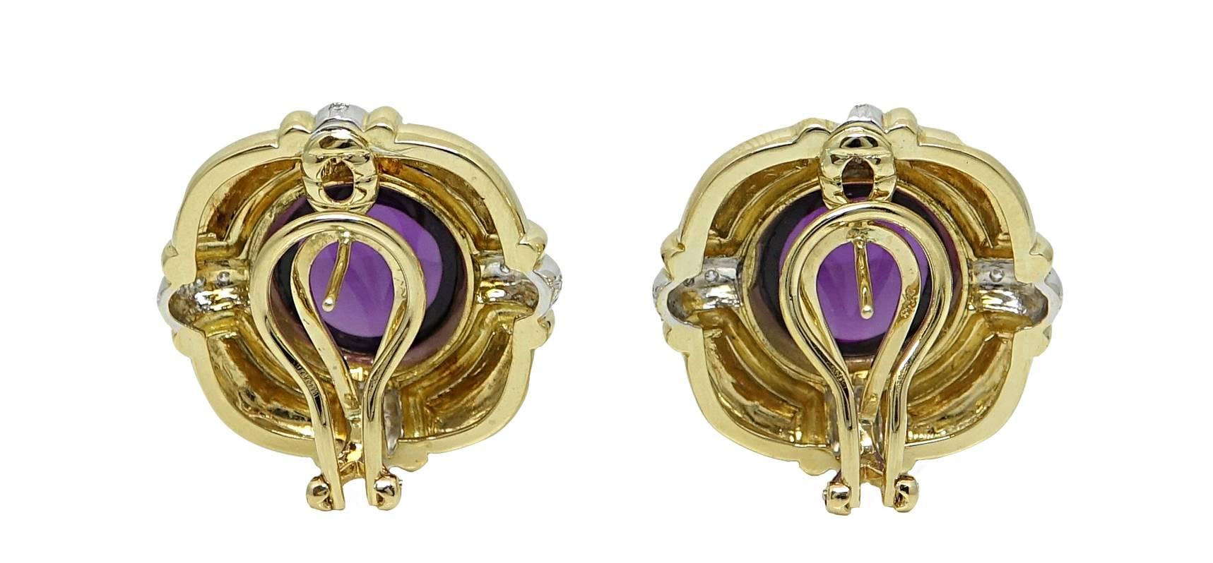 18K Yellow Gold Earrings With Center CaboChon Amethyst Weighing A Total Carat Weight Of 26.00. Each Side Of These Earrings Have A Small Detailing Of Diamond Surrounded By White Gold. These Earrings Have A Lever Back Closure. 