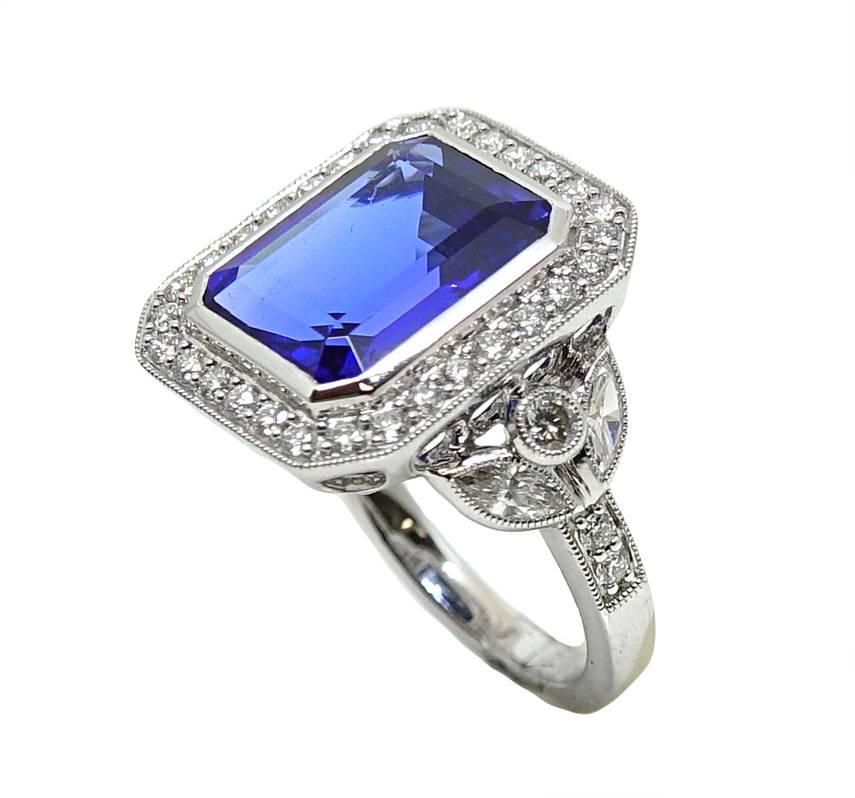 18K White Gold Ring With a Emerald Cut Tanzanite Stone In The Center Weighing A Total Carat Weight Of 7.03 Carats. 4 Marquise Diamonds Are Found On The Side Of This Ring Weighing A Total Carat Weight Of .40 Carats G-H Color and VS2 Clarity. The