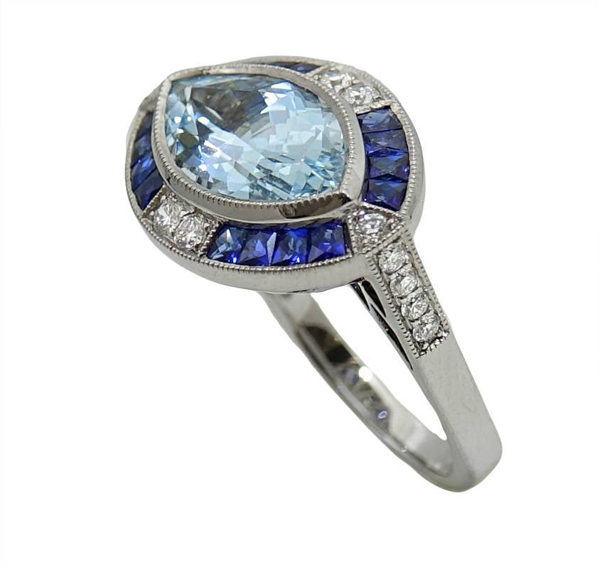 18K White Gold Ring With A Marquise Cut Aquamarine Weighing A Total Carat Weight Of 3.08 Carats. 16 French Cut Sapphires Boarder The Aquamarine and Weigh A Total Carat Weight Of 1.13 Carats. A Total Of 14 Diamonds Are Along The Boarder Of This Ring