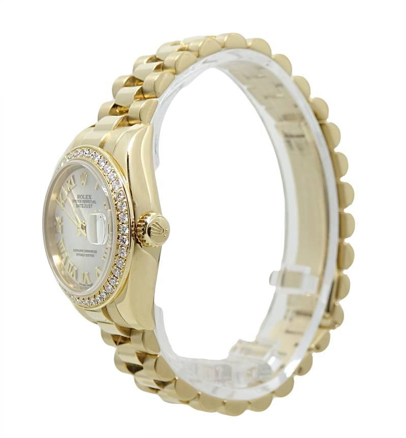 This Rolex Ladies President Is 18K Yellow Gold on A Yellow Gold Rolex President Bracelet And An Original Diamond Set Bezel and a 26mm Case. The Dial On This Watch Is Beautiful White Jubilee Mother Of Pearl With Yellow Gold Hands And Yellow Gold