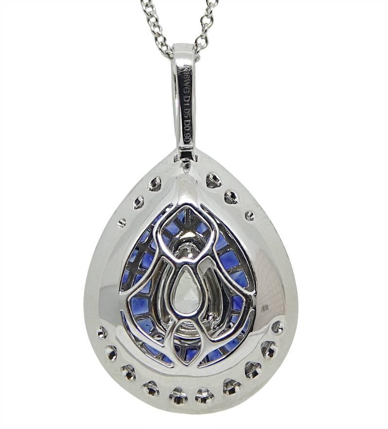 18K White Gold Stadium Pendant With A Beautiful Center Pear Shaped Diamond Weighing A Total Carat Weight Id .90 Carats H Color and VS2 Clarity.  The Vibrant Sapphires On This Pendent Weigh A Total Carat Weight Of 1.01 Carats. The Diamonds That