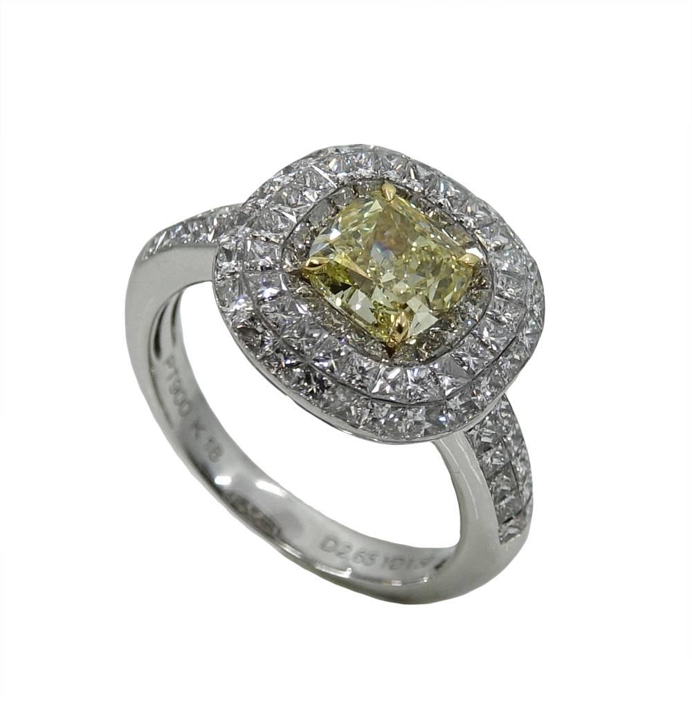 This Sparkling Platinum and 18K Yellow Gold Ring Has A Beautiful Cushion Cut Fancy Yellow Diamond Weighing A Total Carat Weight Of 1.50 Carats, FY Color and SI1 Clarity. Around The Center Stone There Are Lovely Invisible Set Princess Cut Diamonds