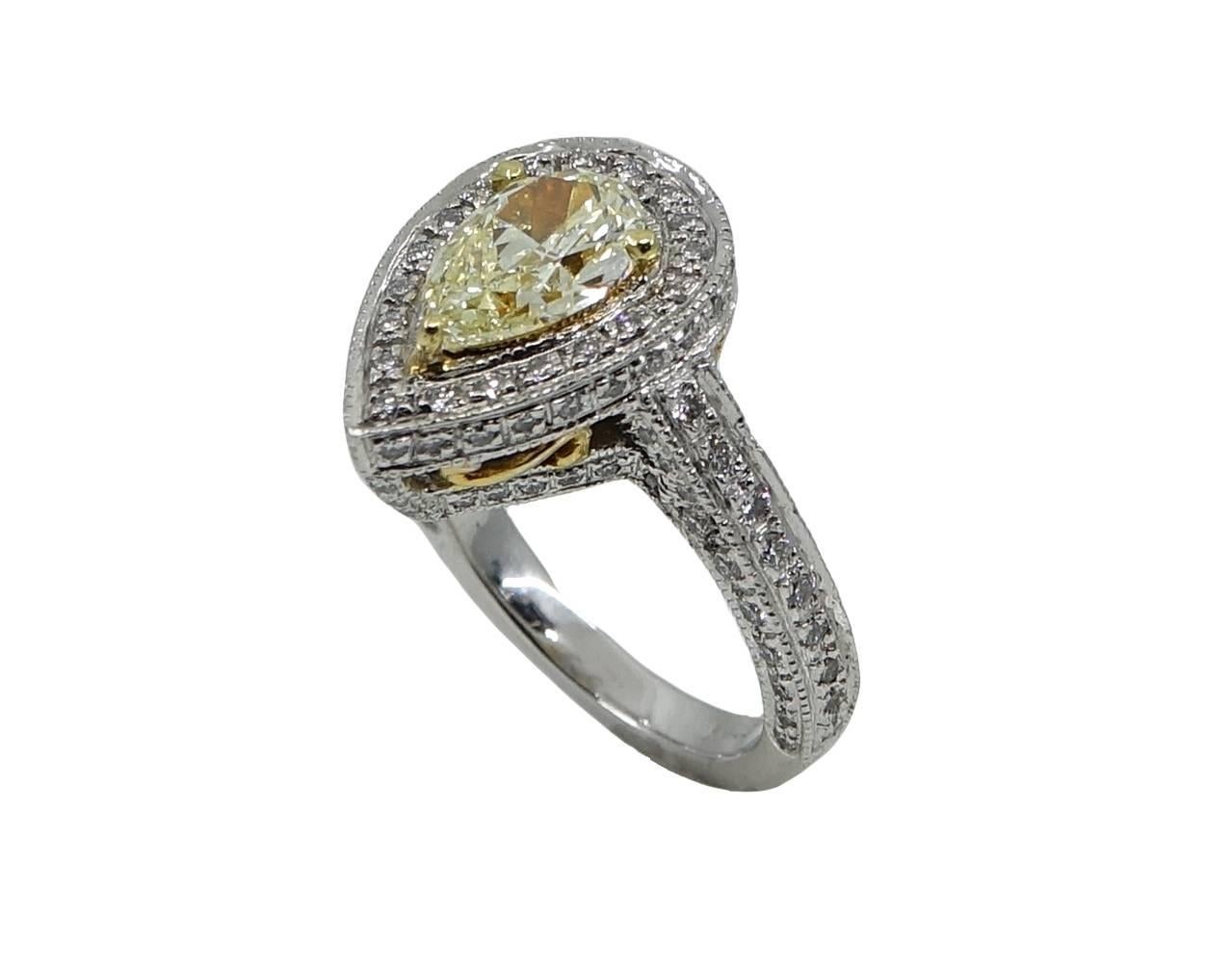 This Lovely and Simple this Platinum Engagement Ring Has A Center Pear Shaped Light Yellow Diamond Weighing A Total Carat Weight Of 1.33  , and VS Clarity. Along The ring is complemented with 122 Round Diamonds Weighing A Total Carat Weight Of .86