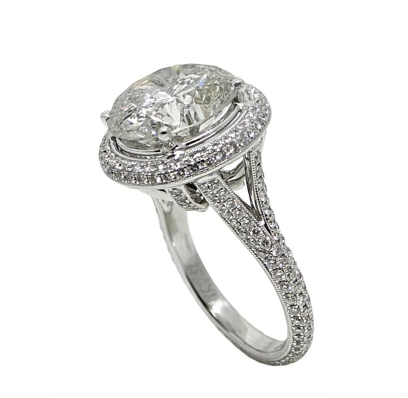 This Gorgeous 18K White Gold Engagement Ring Has A Breath Taking Round Brilliant Diamond In The Center Weighing A Total Carat Weight Of 6.47 Carats, J Color and Imperfect Clarity. The Mounting On This Ring Is Covered In Round Diamonds Weighing A