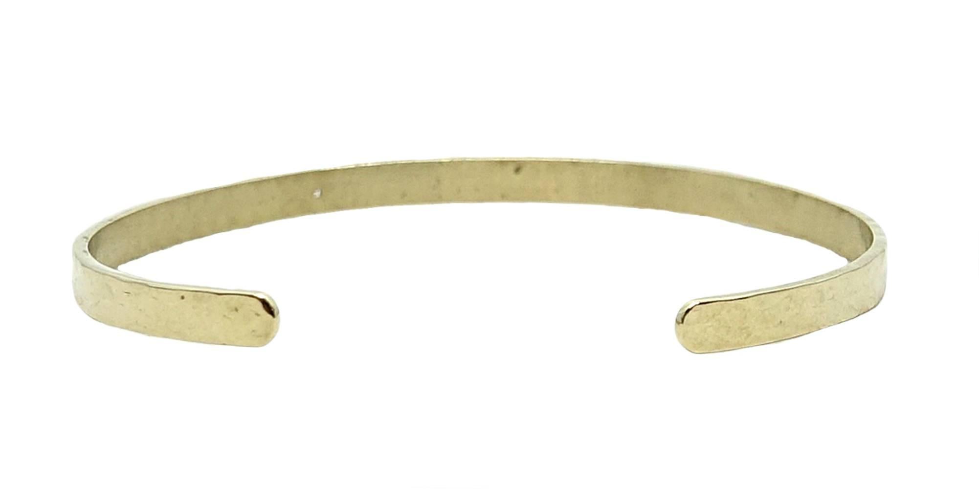 This Simple and Sweet 14K Yellow Gold Julez Bryant Cuff Is A Thin Style, Which Makes It Perfect For Pairing With Other Cuffs and Bangles. There Is One Offset Round Diamond That Weighs A Total Carat Weight Of 0.02 Carats. 