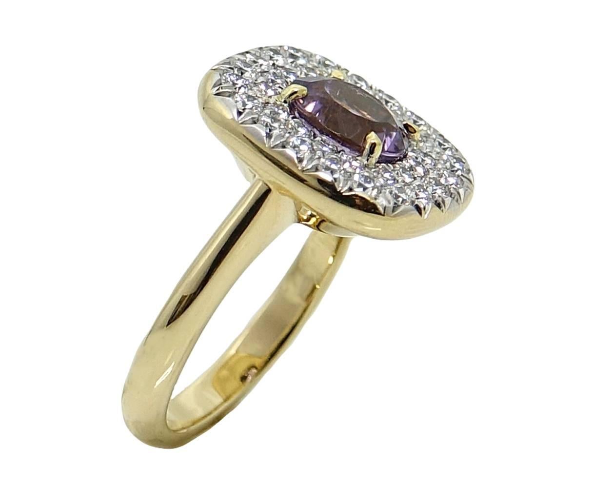 This Sparkling 18K Yellow Gold Ring Has An Eye Catching Round Lilac Tourmaline Stone Weighing A Total Carat Weight Of 1.83 Carats. Diamonds Surround The Tourmaline and Weigh A Total Carat Weight Of .92 Carats. This Lovely Ring Is A Size 6.