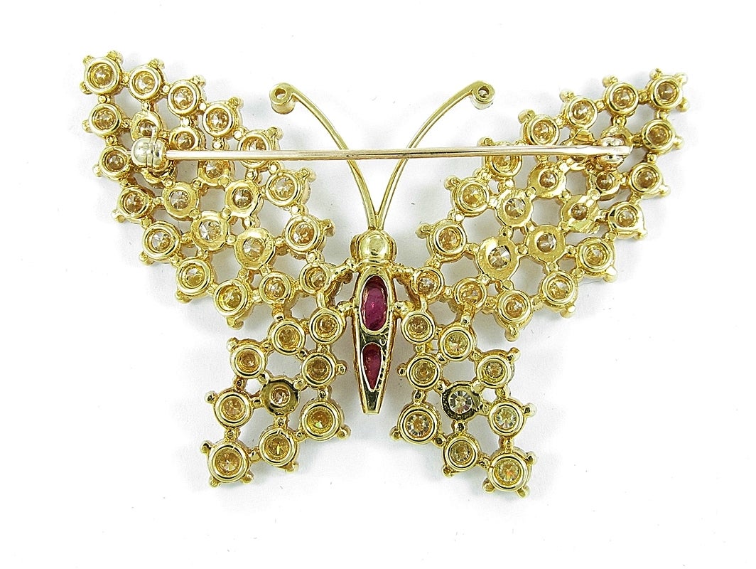 Up for sale is this beautiful estate pin/brooch butterfly. Body accents of cameo rubies and eyes of emeralds with wings that are scattered with high quality round brilliant diamonds all set in 18K Yellow Gold. This brooch is 2 1/8