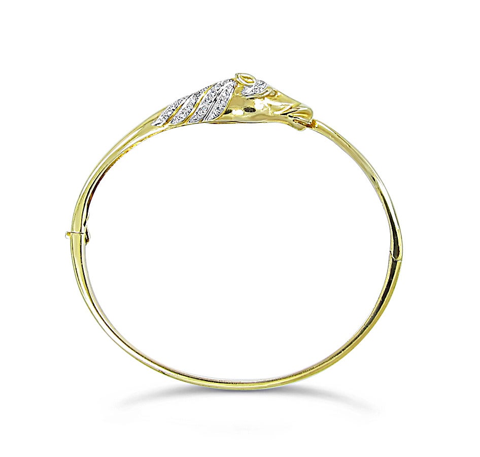 This Horse Head and Tail Bangle Bracelet is made of 18k yellow gold and holds 49 round brilliant diamonds prong set in 18k white gold. The strong and sturdy bracelet is approximately 7