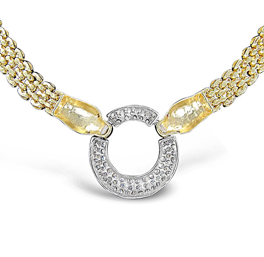 Here is a beautiful estate piece of jewelry. The panther necklace is made in 14k yellow gold marquise links with 5 rows. Both panthers support round ruby eyes. The circle in the center holds approximately 59 round brilliant cut diamonds which have a
