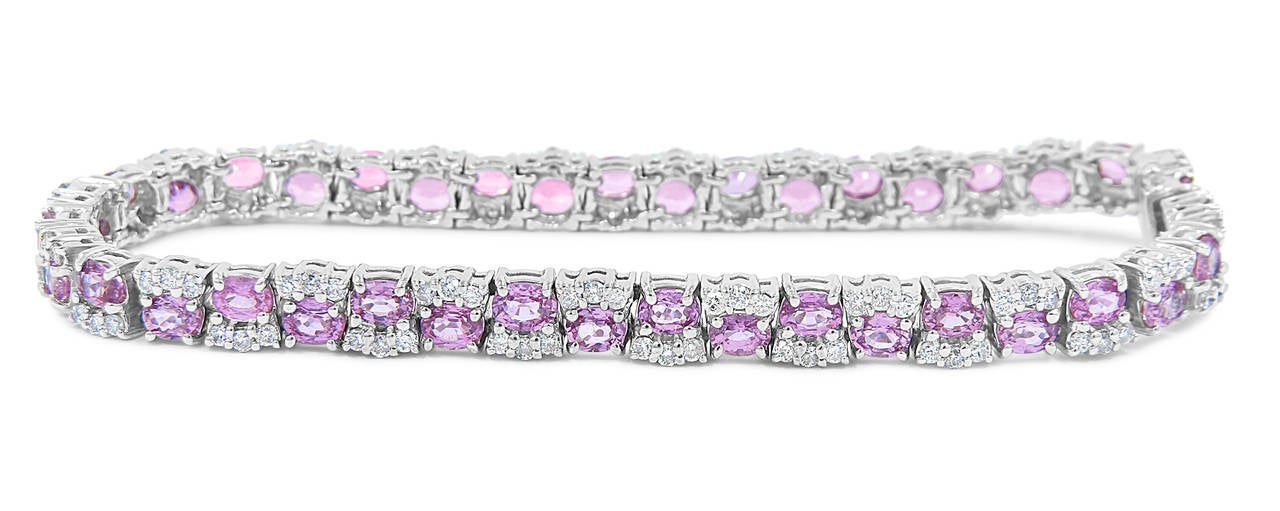 There are 40 oval pink sapphires that are 3 x 4mm each. There are 120 round brilliant diamonds at approximately .02cts each, all securely prong set in 14k white gold. Bracelet measures 7.25 inches long and is .19 inches wide.