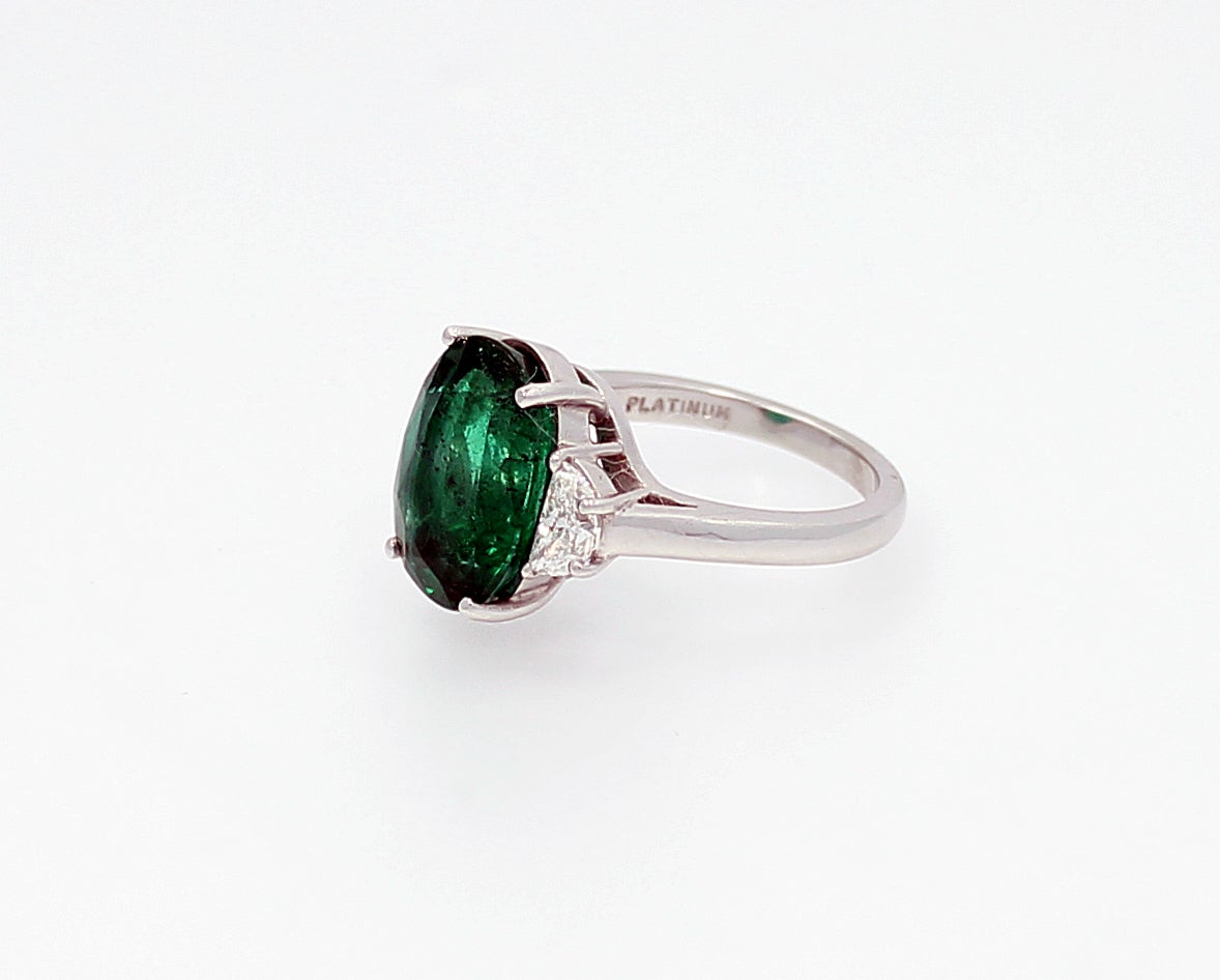 Beautiful Platinum ring with a 5.36 carat Oval Emerald and two side half moon diamonds with a total of .72 carats. Stunning.