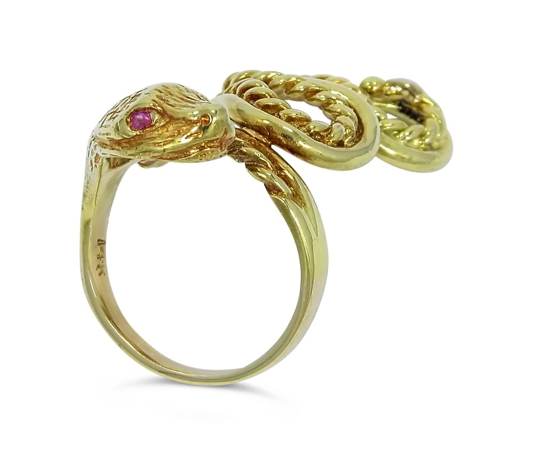 This snake ring is made of 14k yellow gold. The two ruby eyes are approximately 1.5mm each. Ring is 1.38 inches long and .75 inches wide.