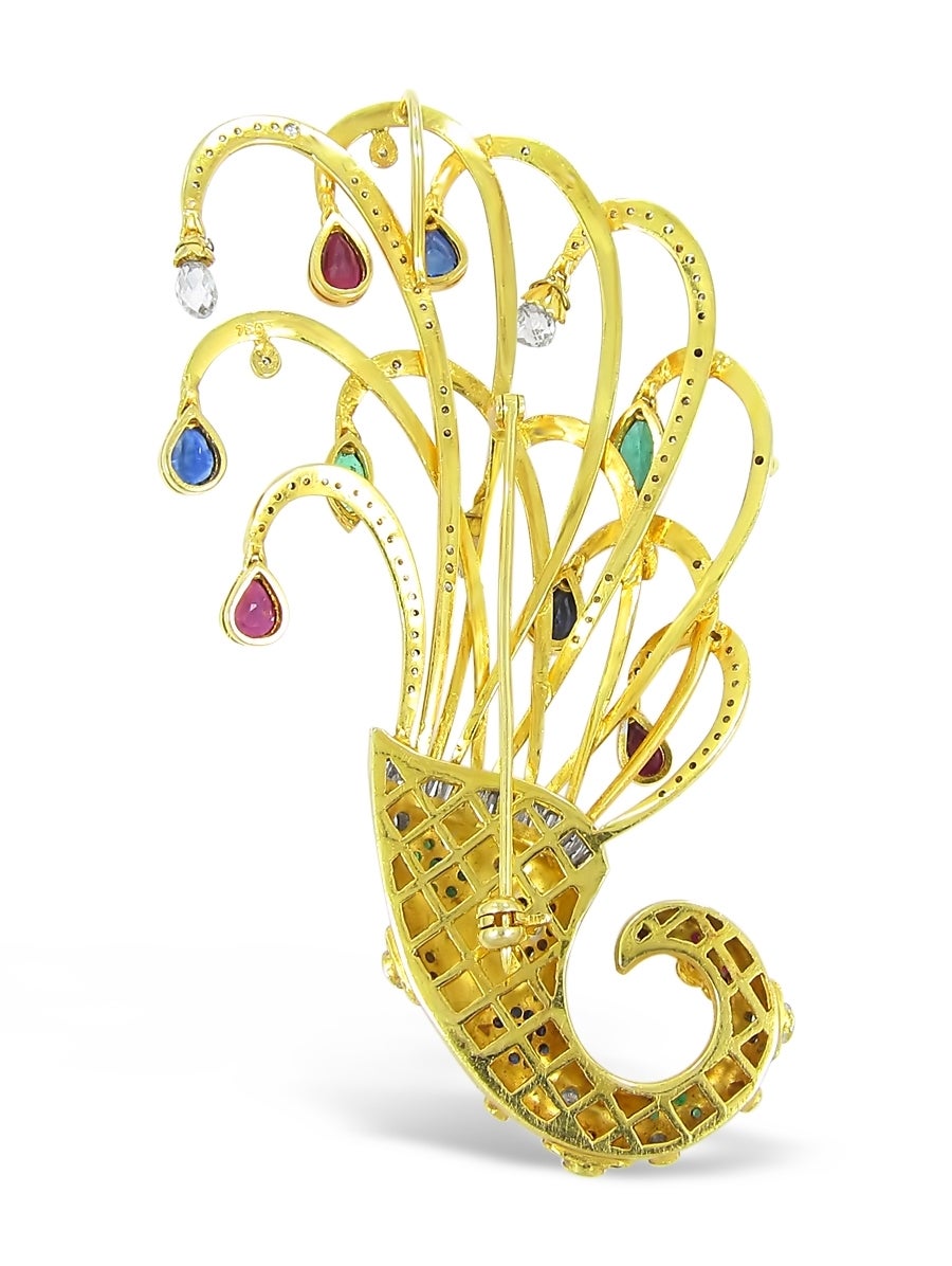 This is an exquisite cornucopia brooch which has all of the elements of a master jeweler. There are approximately 2.50cts of diamonds including the briolette diamonds on this brooch and 4cts of gemstones including rubies, emeralds and sapphires. The