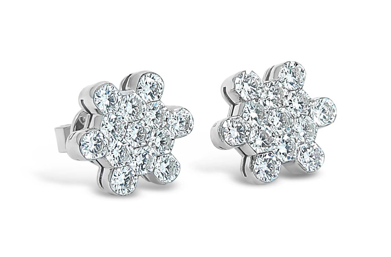 D'Annunzio Snowflake earrings hold 10 round brilliant cut diamonds of great quality (G/VS1) in each earring. All securely prong set in 18k white gold. Original friction backs. Earrings measure .44 inches.