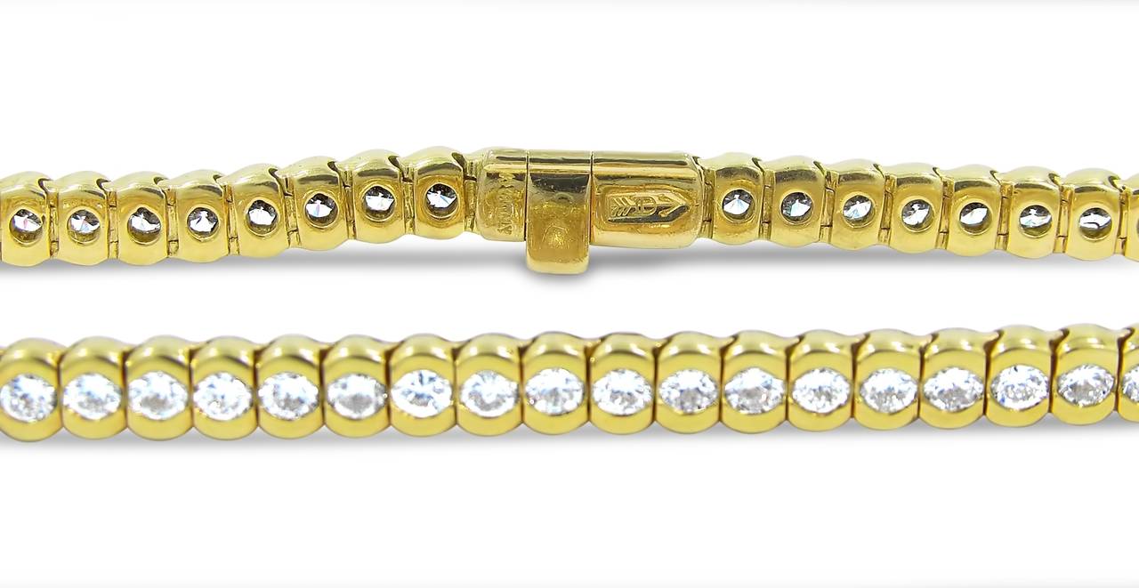 This tennis bracelet created by Craig Drake holds 58 round brilliant cut diamonds with a total combined estimated weight of 5.40cts. Each diamond matches in great quality and all are bezel set in 18k yellow gold with a high polish. Bracelet is in