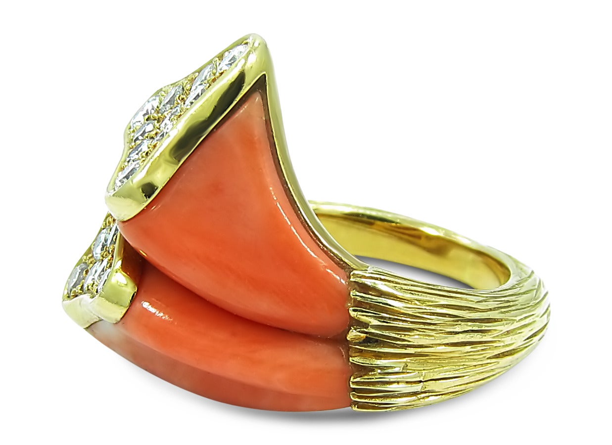 This ring holds two very uniquely shaped coral pieces. Atop each coral piece lies 17 round brilliant diamonds of good quality and color weighing approximately .06cts each. Ring is created with 18k yellow gold with a nice bark design along each side