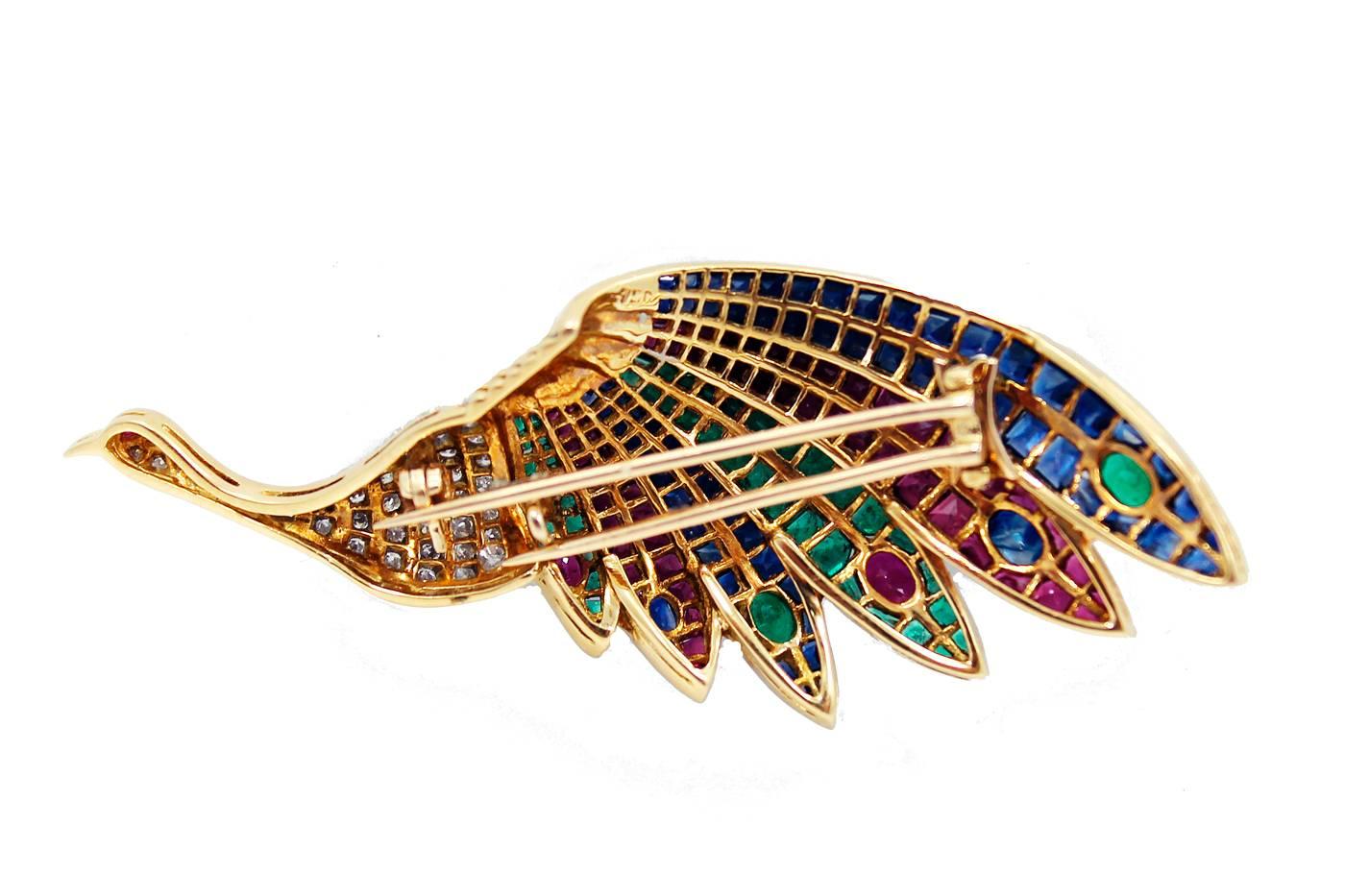 18K Yellow Gold Peacock Brooch with precious stones, This brooch contains 176 precious stones which include Rubies, Sapphires and Emeralds for a total of 10.60 carats. It also contains 42 Round Brilliant Cut Diamonds with a total of .75 carats, H-I
