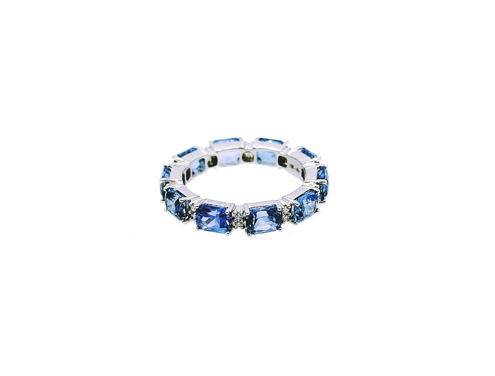 18K White Gold Eternity Band with Blue Emerald Cut Sapphires which equal 5.09 carats and Round Brilliant Diamonds which equal .16 carats. The ring is a size 7 and in excellent condition. 