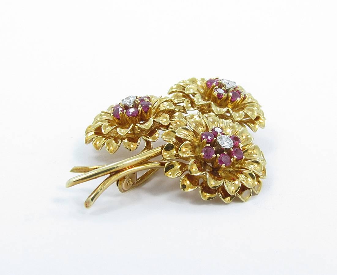 Up for sale is this beautiful Tiffany & Co. Ruby and Diamond flower Pin in 18k yellow gold. The 3 diamonds have beautiful quality and equal approximately .25ctw. There are 18 full cut rubies that measure 2mm each and are all securely prong set. The