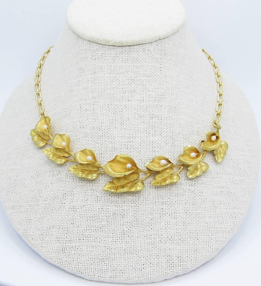This necklace is created in 18k yellow gold. The flower petals each contain a small pearl that averages 3.2mm in diameter. A lot of time was put into creating the detail on the petals and leaves. Necklace weighs 34.9 grams. There is little wear on