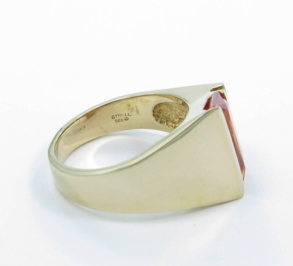 We are pleased to offer this beautifully crafted Strell Designer Padparadscha Sapphire ring. Ring is 14k yellow gold with a very nice high polish showing little signs of wear. Center Padparadscha Sapphire is of great quality with four round