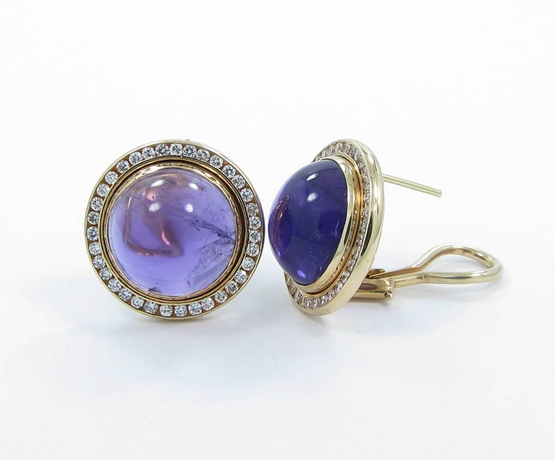These earrings hold a beautiful color cabochon Amethyst that measures 13.50mm in diameter x 7.50mm in depth. There is approximately .72cts combined of round brilliant cut diamonds securely channel set which give these earrings a total diameter of