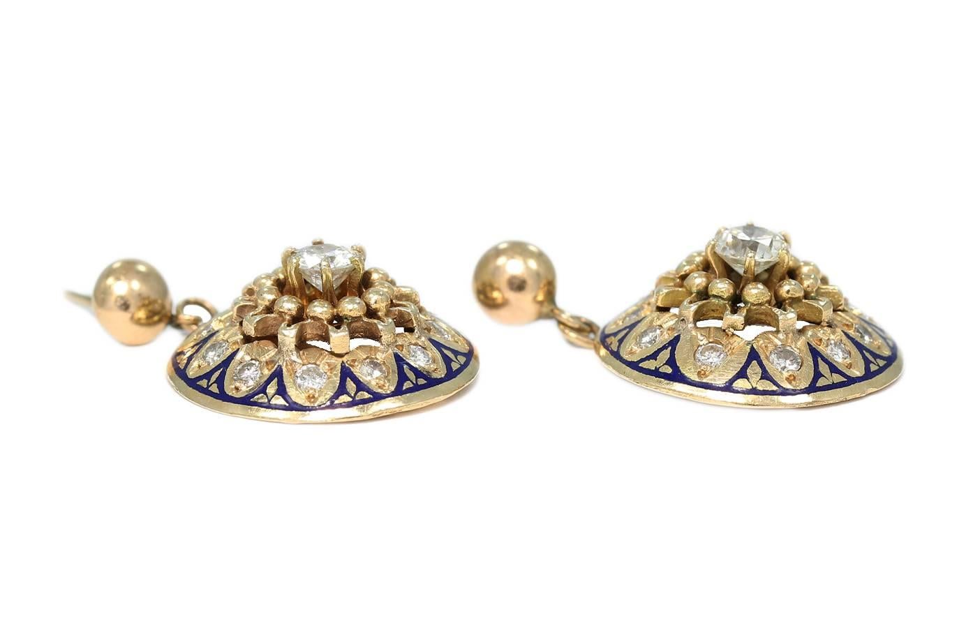 These beautiful estate earrings are created in 14k yellow gold with blue enameling and round diamonds. Center diamond in each earrings weighs approximately .50cts with an additional .22cts on each earring. The main section of the earrings has a