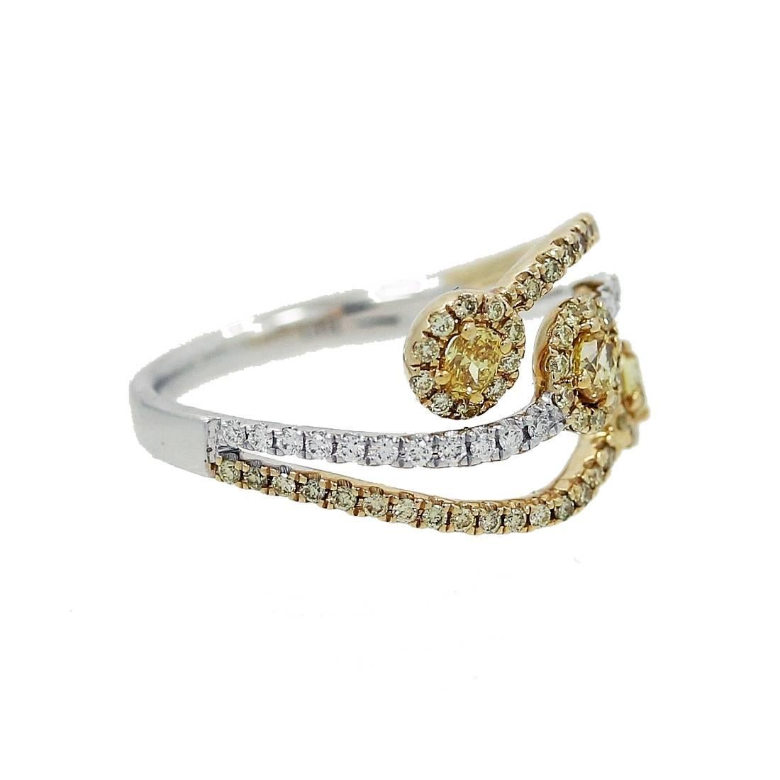 White and Yellow Gold Ring with 3 Oval Fancy Yellow Diamonds equal to .32 carats and Round Brilliant Yellow Diamonds equal to .32 carats. The ring is a size 7 but can be sized upon request.