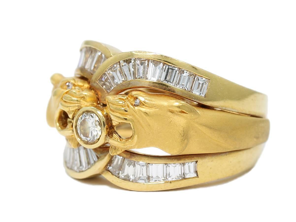 This Carrera Y Carrera double panther head ring is created with 18k yellow gold. In between the two heads is a .20ct round brilliant cut diamond securely bezel set. The eyes are also of diamonds. There are round diamond eyes and baguette diamonds