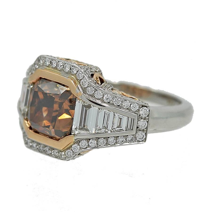 18K White Gold Ring with a Natural Fancy Dark Orangy Brown Cushion Cut Diamond weighing 4.01 carats and is SI2 in Clarity. the ring also features 1.19 carats in trapezoids, G Color VS Clarity and Round Brilliant Diamonds weighing 1.10 carats in
