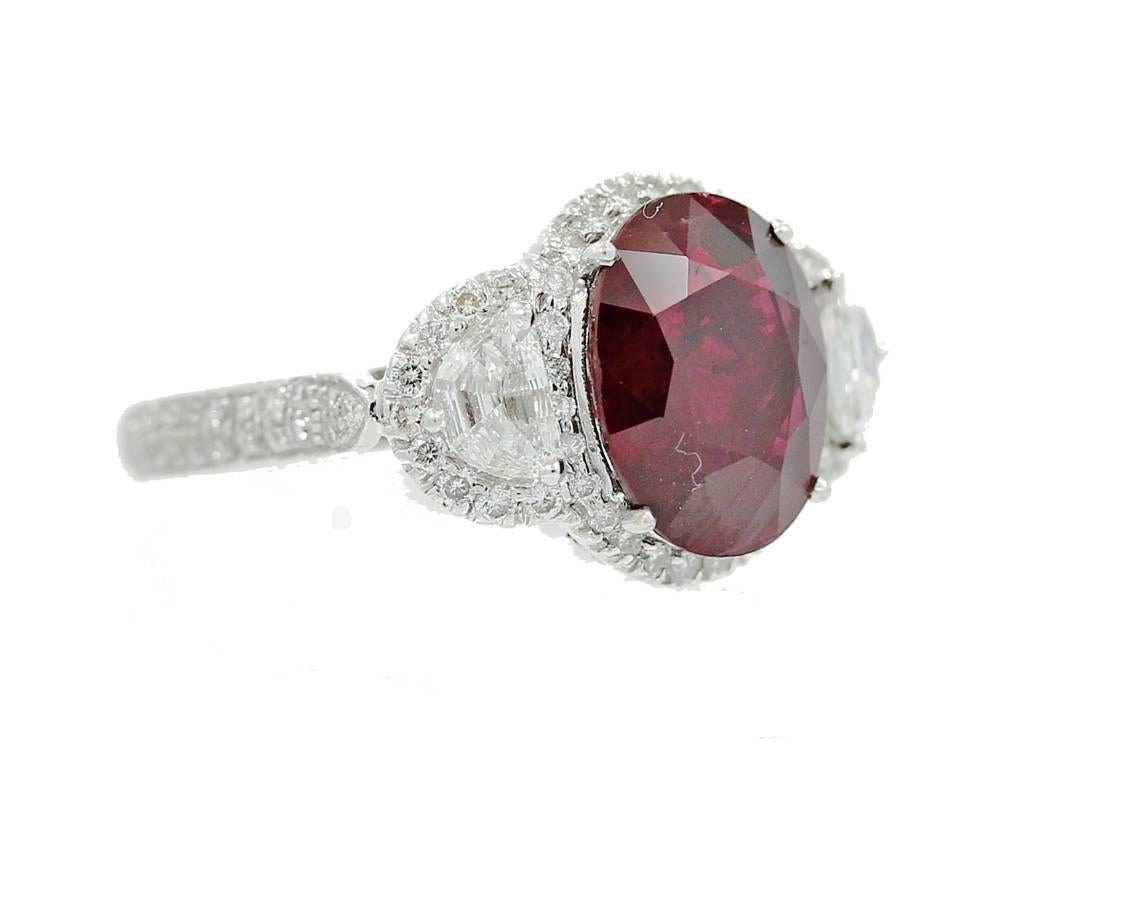 18K White Gold Ladies Ring with a Oval 5.05 Carat Heated Burma Ruby with Two Half Moon Diamonds and Round Brilliant Diamonds on the Mounting. The diamonds weigh a total of 1.35 carats. The ring is a size 7 but can be sized upon request.