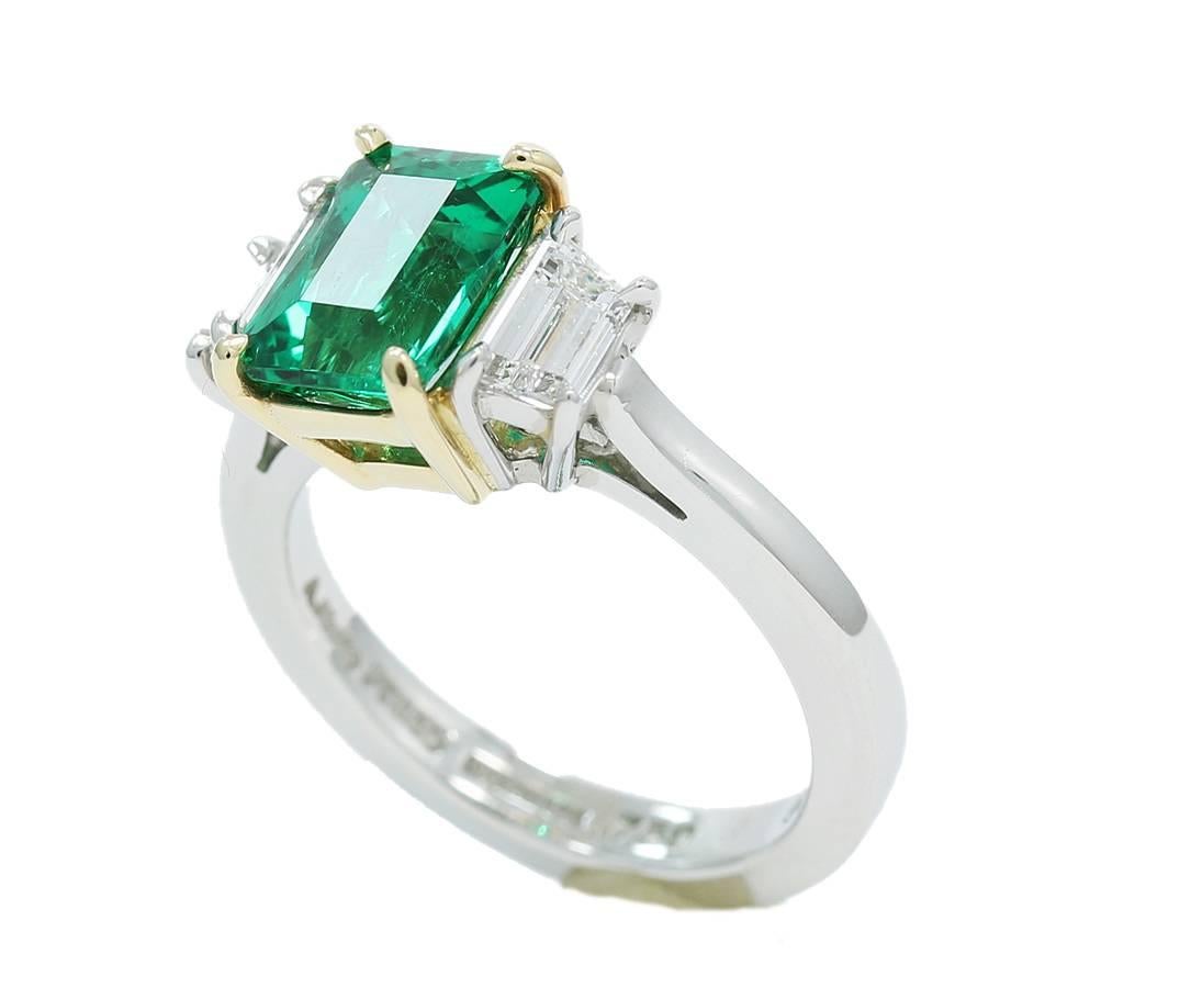 This amazing ring holds a 1.90ct emerald center that has an AGL Report. Copy of AGL Report has been attached to photos. The Trapezoid diamonds are 0.72cts tw. Emerald is set in 18k yellow gold while the diamonds are set in platinum. This beautiful