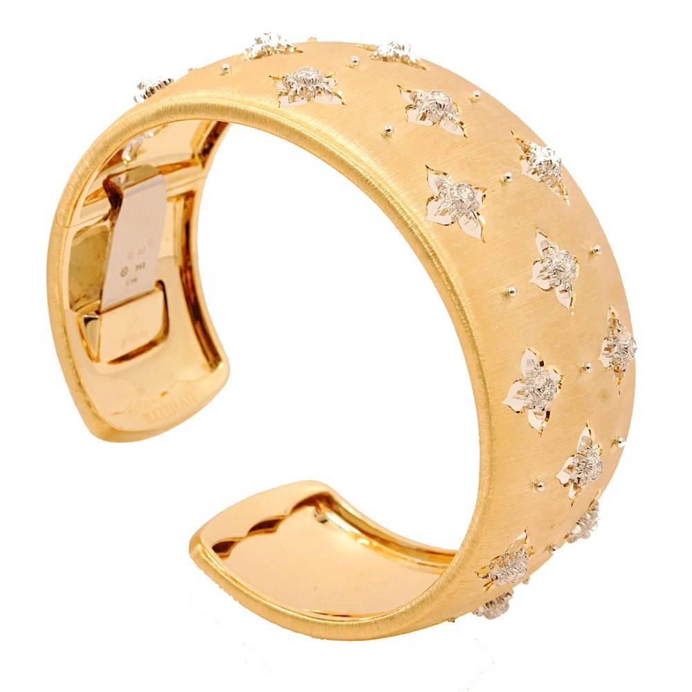 18K Yellow and White Gold Buccellati 3.0CM Macri Giglio Cuff Bracelet. This Hand Made Buccellati Cuff which comes with Round Brilliant Cut Diamonds which equal to .76 carats in total weight. The cuff has never been worn and comes in Buccellati