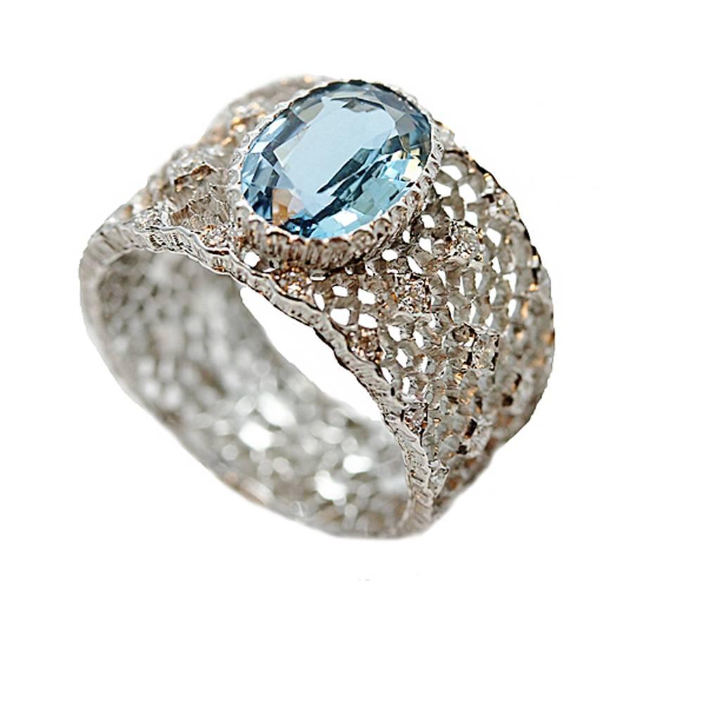 18K White Buccellati Musone Band. This Buccellati Ring was hand made in Italy and has a Aquamarine Center Stone which weighs 1.58 carats and Round Brilliant Diamonds on the band which weigh a total of .20 carats. It has never been worn and it is a