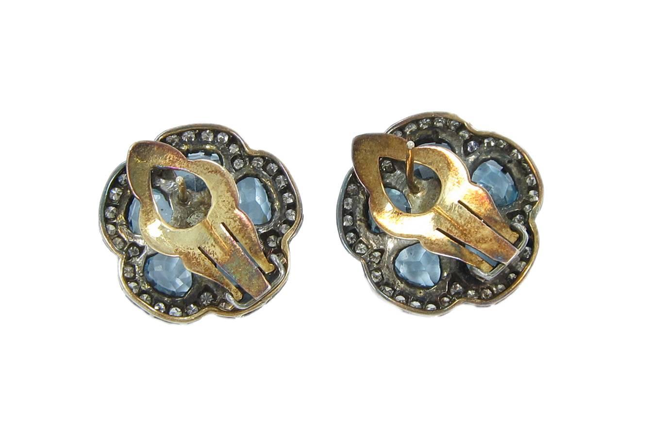 These beautiful 14k yellow gold and sterling silver diamond earrings hold five blue topaz all securely prong set. The silver on these earrings show tarnished and wear. Earrings have not been polished to keep the vintage look. The backings hold