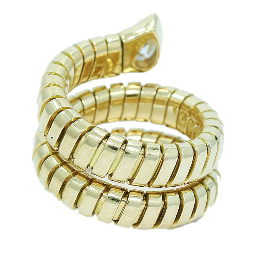 Up for sale is this beautiful 18k yellow gold Bulgari Tubogas coil snake ring. The ring holds one (1) pear shape diamond weighing approximately 0.33cts tw. Ring sits at a size 5-6 (the ring stretches) It measures 0.75" in height and weighs a