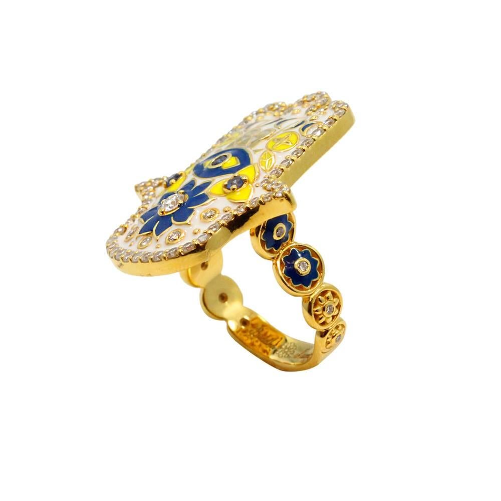 20K Buddha Mama Yellow Gold White Enamel Hamsa Ring With Diamonds Weighing A Total Weight Of 1.02ct And Blue Sapphires Weighing A Total Carat Weight Of 0.12ct. This Ring Is A Size 7.