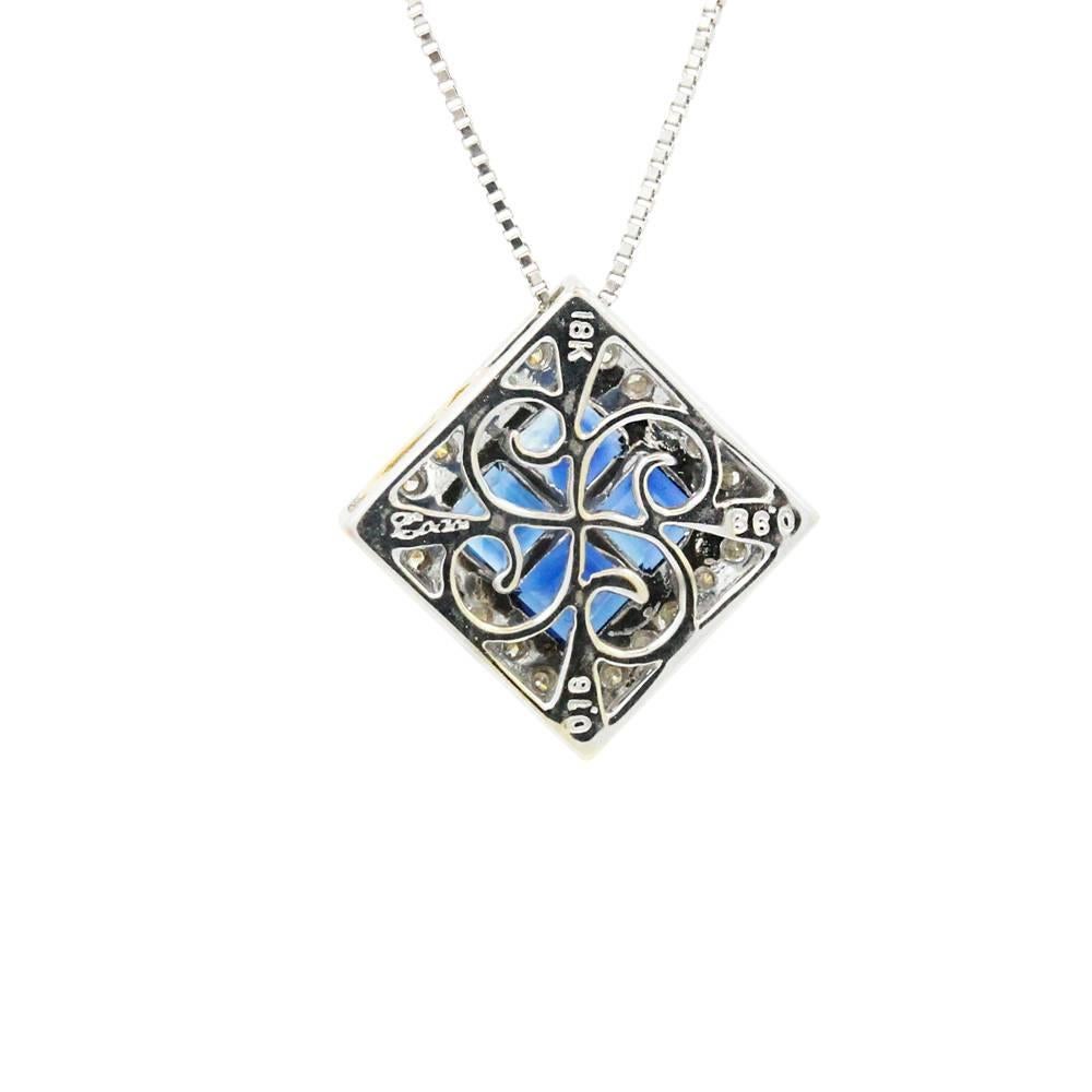 18K White Gold Pendent With Invisible Set Blue Sapphires Weighing A Total Carat Weight Of 0.98ct And Surrounding Round Brilliant Cut Diamonds Weighing A Total Carat Weight Of 0.16ct.