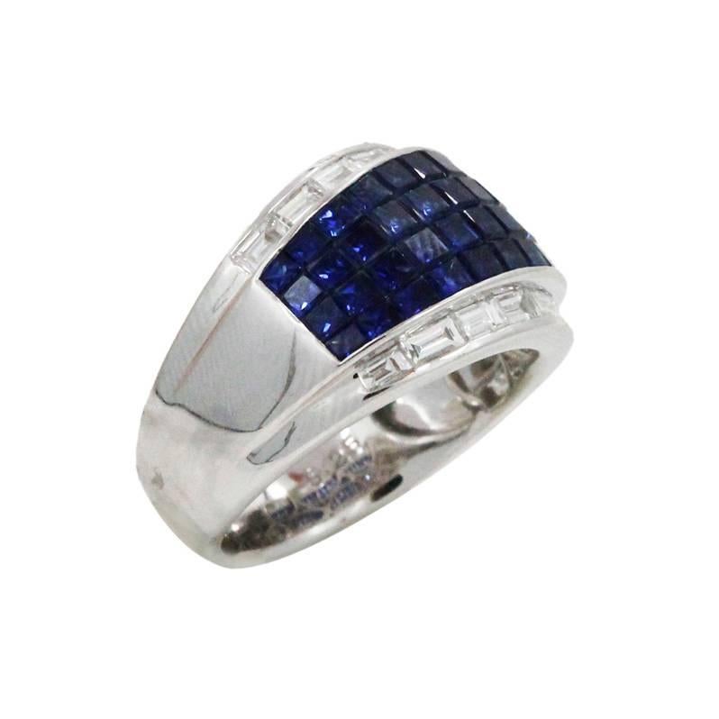 18K White Gold Ring With 48 Princess Cut Blue Sapphires Weighing A Total Carat Weight Of 5.25ct and 16 Surrounding Diamonds Weighing A Total Carat Weight Of 1.00ct. This Ring Is A Size 7.5.