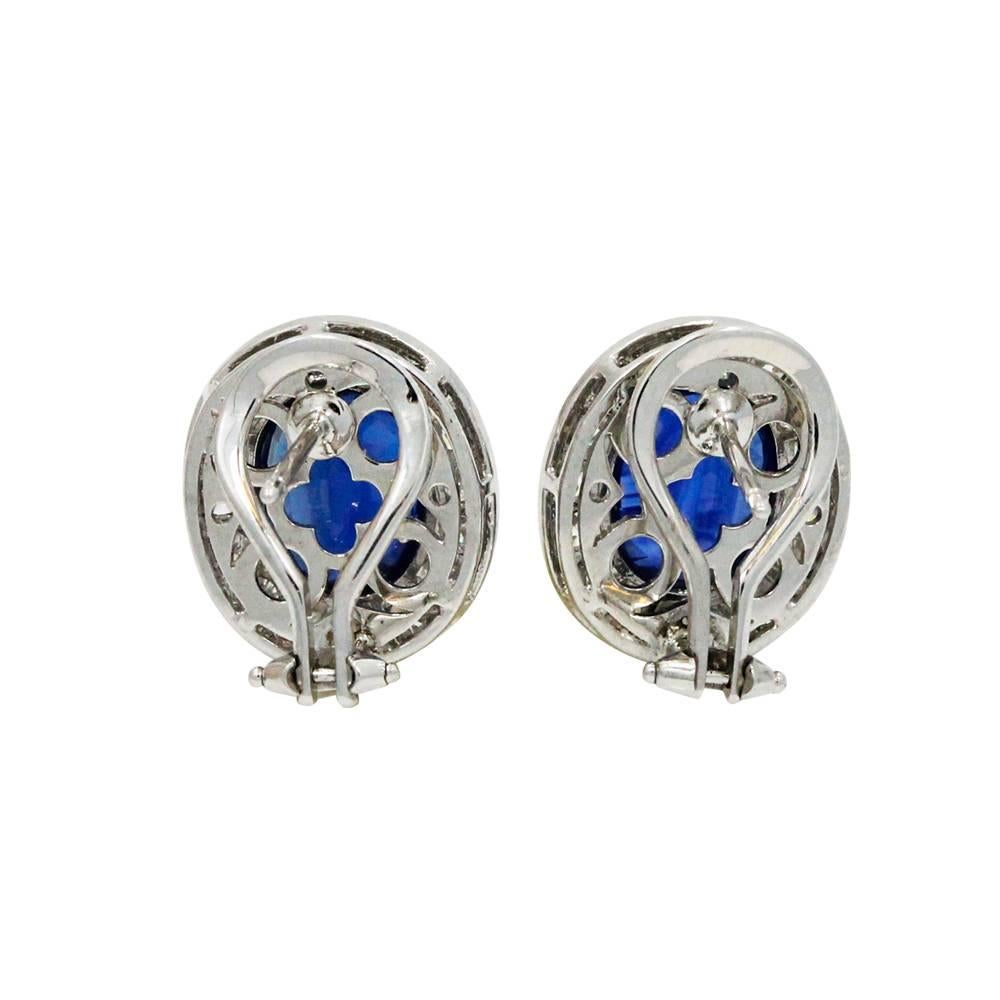 Platinum Earrings With Center Oval Cut Sapphires Weighing A Total Carat Weight Of 9.12ct And Surrounding Round Cut Diamonds Weighing A Total Carat Weight Of 1.70ct. These Earrings Are .5 Inches In Length.