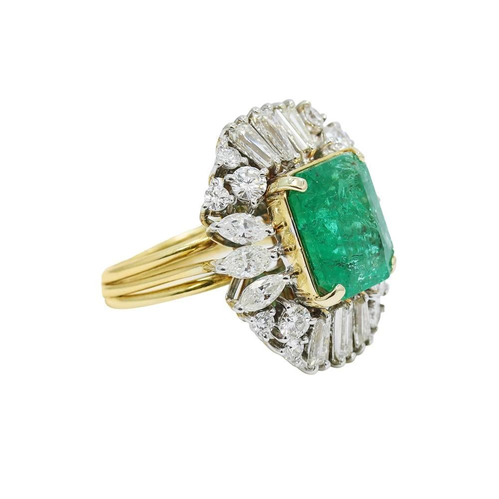 Up for sale is this 18k white and yellow gold emerald and diamond ring. The emerald is approximately 5.00 carats, with twenty four (24) baguette, round, and marquise shaped diamonds weighing approximately 2.25 carats total weight. It measures 1.00